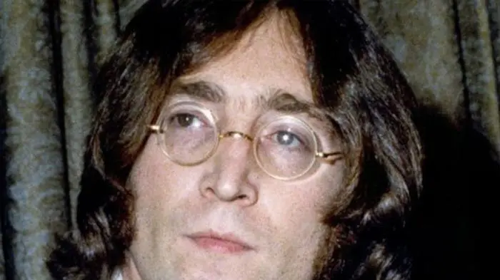 Close-up of a man with glasses and long hair.
