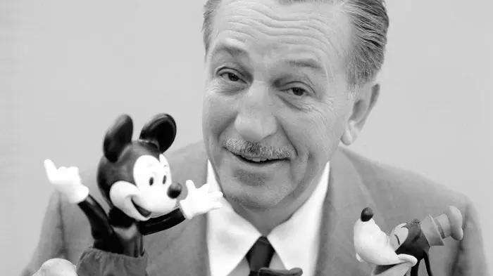 Black and white photo of Walt Disney with a Mickey Mouse puppet.