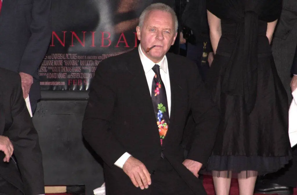 Man in black suit with colorful tie at an event.