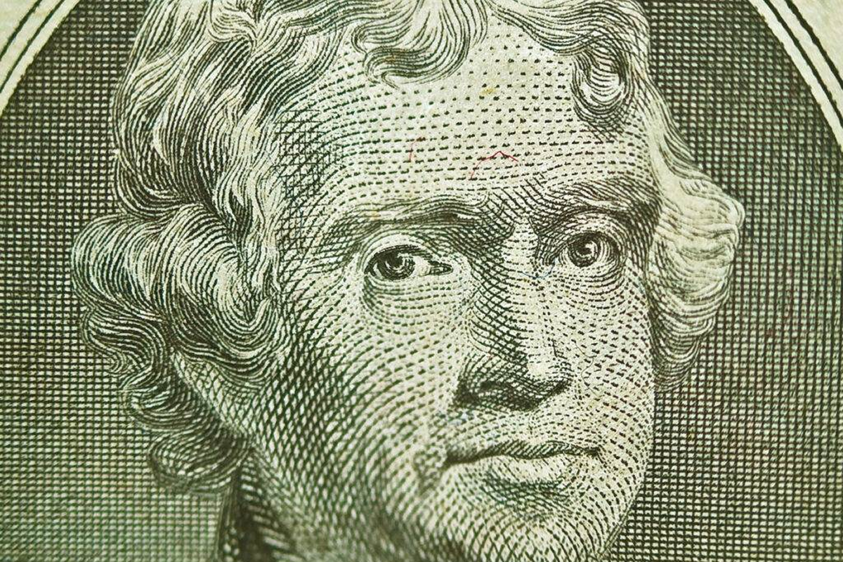 Close-up of a man's engraved portrait on currency.