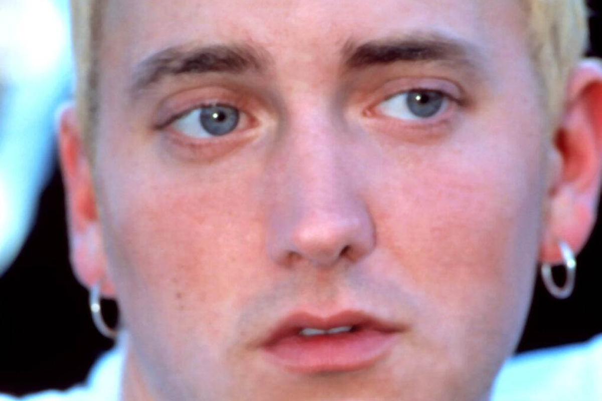 Close-up of a young man with blue eyes and a serious expression.